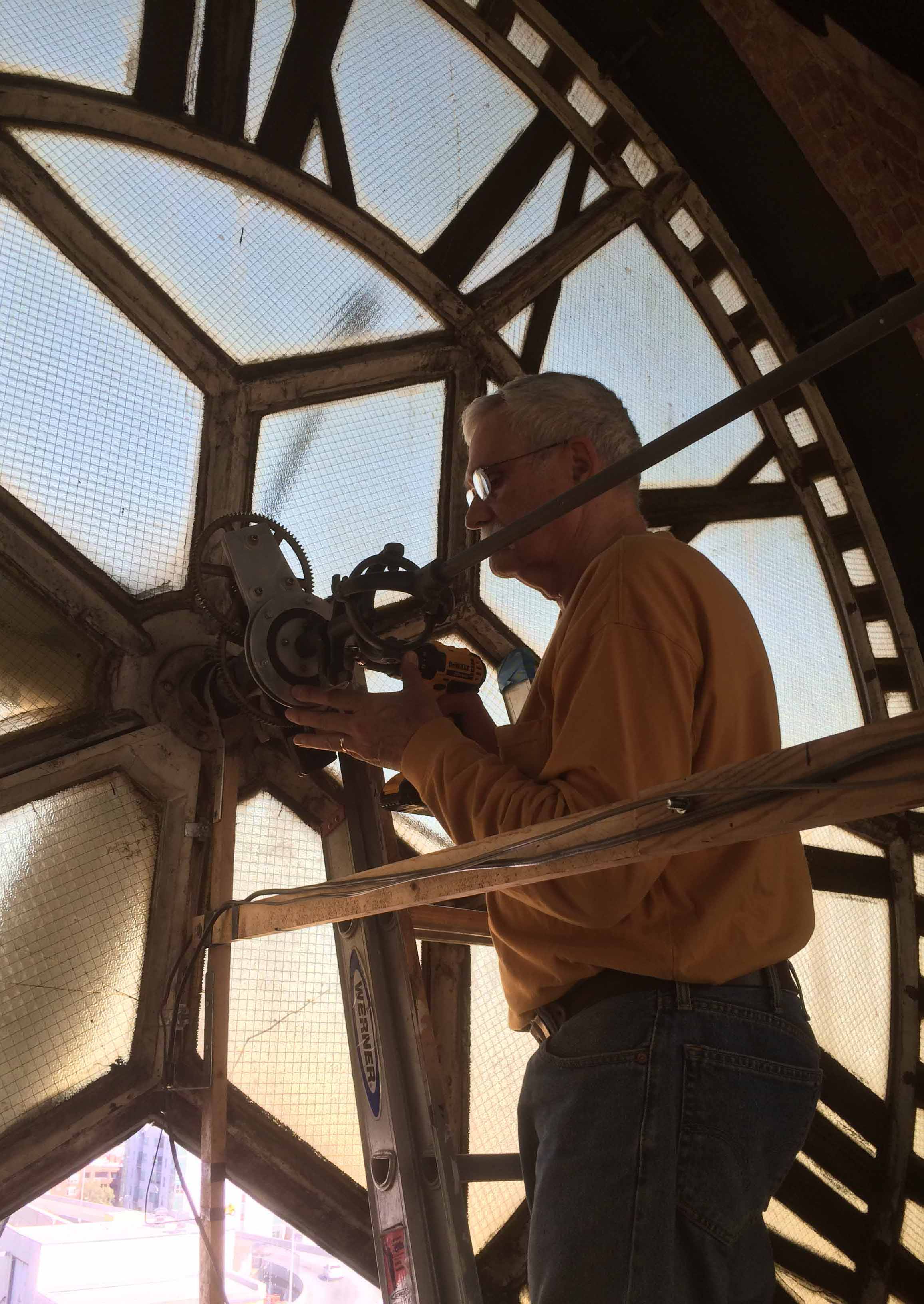 Dorian Clair adjusting the hands of a tower clock